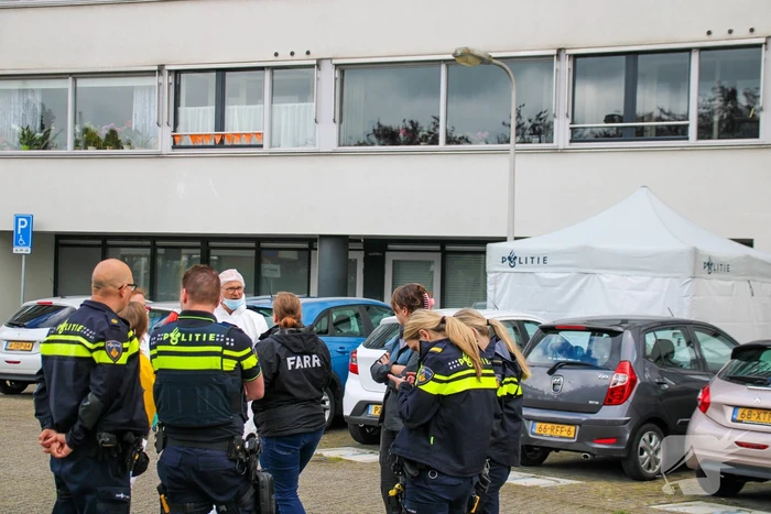 Forensisch onderzoek op parkeerplaats naast flatgebouw