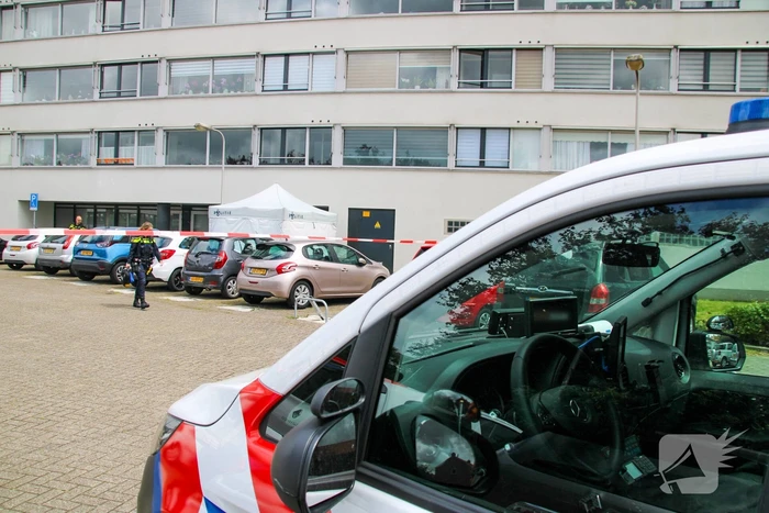Forensisch onderzoek op parkeerplaats naast flatgebouw