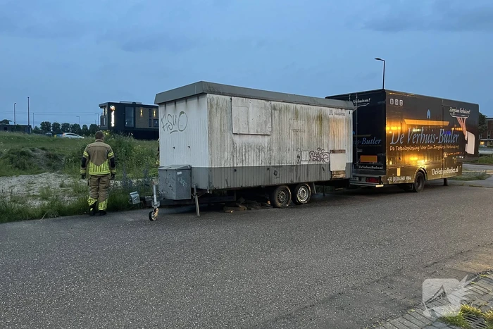 Brandweer blust in brand gestoken bouwkeet vol rommel
