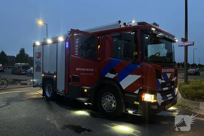 Brandweer blust in brand gestoken bouwkeet vol rommel