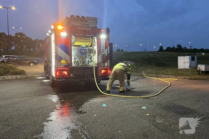 Brandweer blust in brand gestoken bouwkeet vol rommel