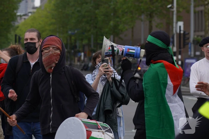 Demonstranten trekken persoon van scooter en slaan op auto's