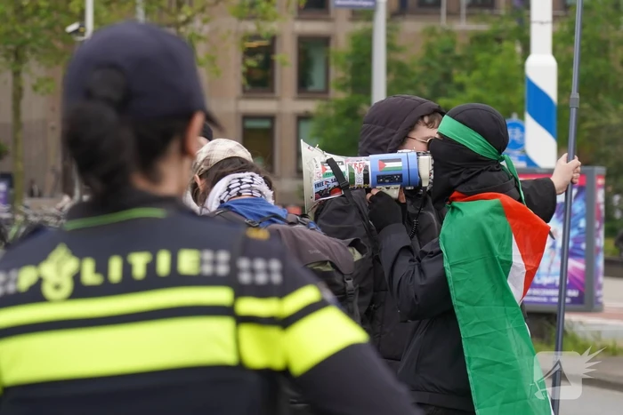 Demonstranten trekken persoon van scooter en slaan op auto's