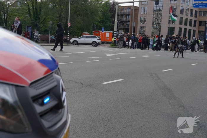 Demonstranten trekken persoon van scooter en slaan op auto's