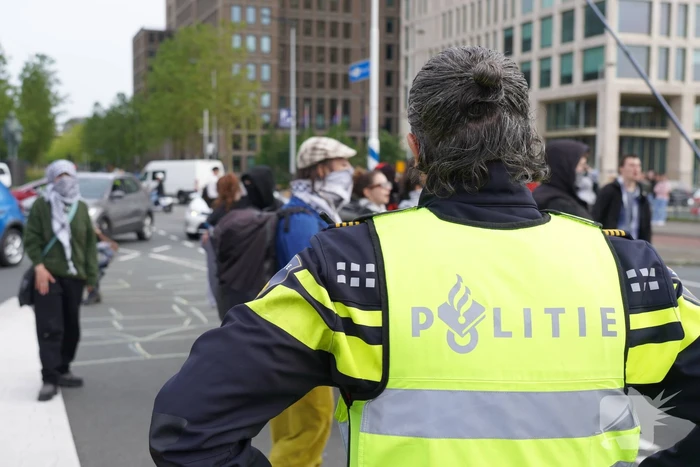 Demonstranten trekken persoon van scooter en slaan op auto's