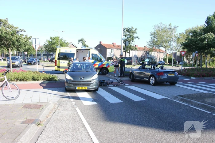 Fietser klapt op zijkant van auto tijdens het oversteken op rotonde
