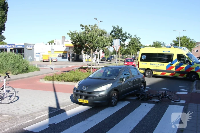 Fietser klapt op zijkant van auto tijdens het oversteken op rotonde