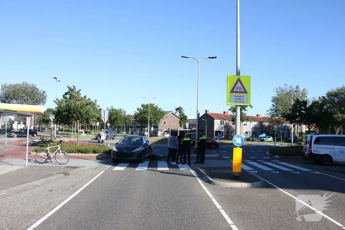 Fietser klapt op zijkant van auto tijdens het oversteken op rotonde