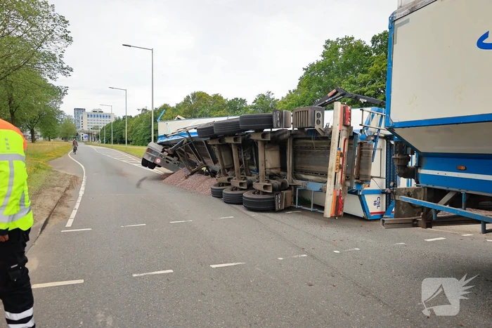Oplegger geladen met grind kantelt