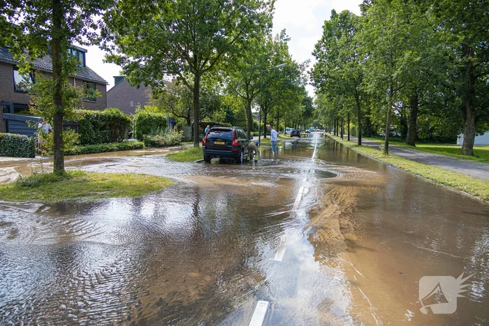 Straat blank door een gesprongen waterleiding
