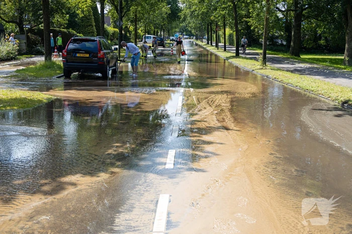 Straat blank door een gesprongen waterleiding