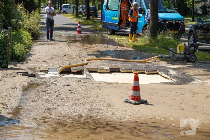 Straat blank door een gesprongen waterleiding