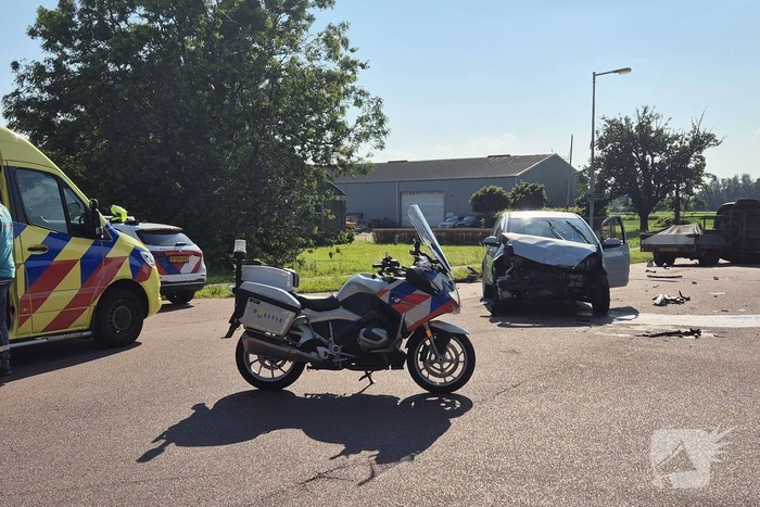 Bestelbus belandt op zijkant na frontale botsing op kruising, automobilist gewond