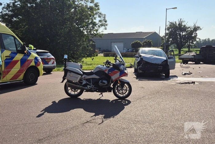 Bestelbus belandt op zijkant na frontale botsing op kruising, automobilist gewond
