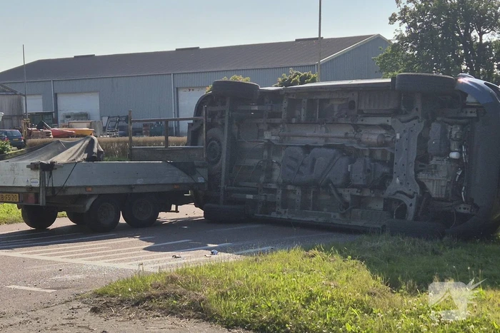 Bestelbus belandt op zijkant na frontale botsing op kruising, automobilist gewond