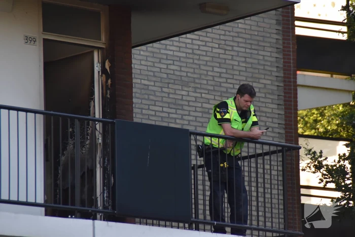 Afval voor voordeur in brand bewoner door brandweer naar buiten begeleidt