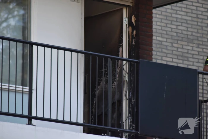 Afval voor voordeur in brand bewoner door brandweer naar buiten begeleidt