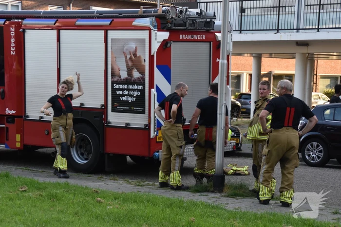 Afval voor voordeur in brand bewoner door brandweer naar buiten begeleidt