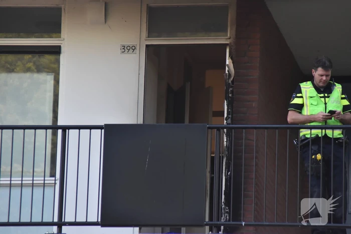Afval voor voordeur in brand bewoner door brandweer naar buiten begeleidt