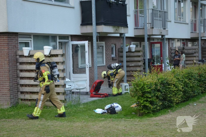 Brandweer blust brand met gieter