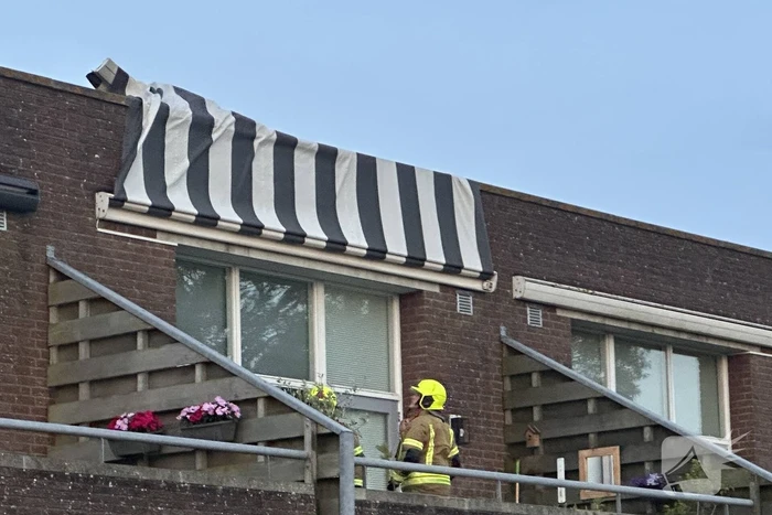 Zonnescherm waait kapot, brandweer ingezet