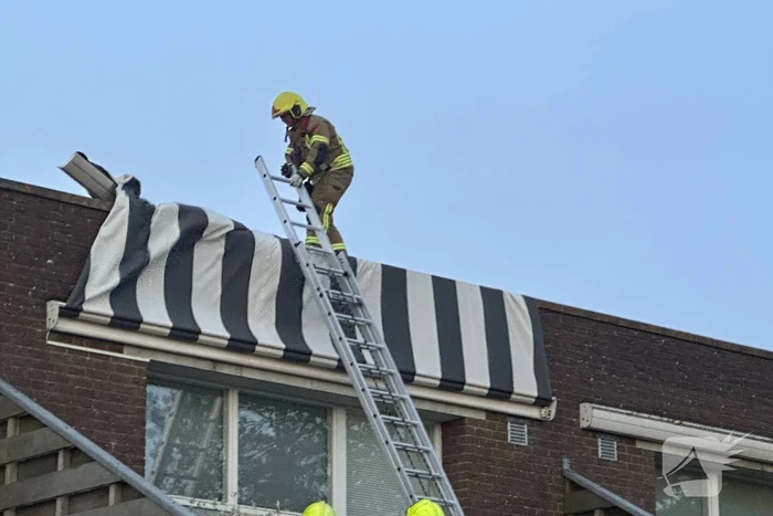 Zonnescherm waait kapot, brandweer ingezet