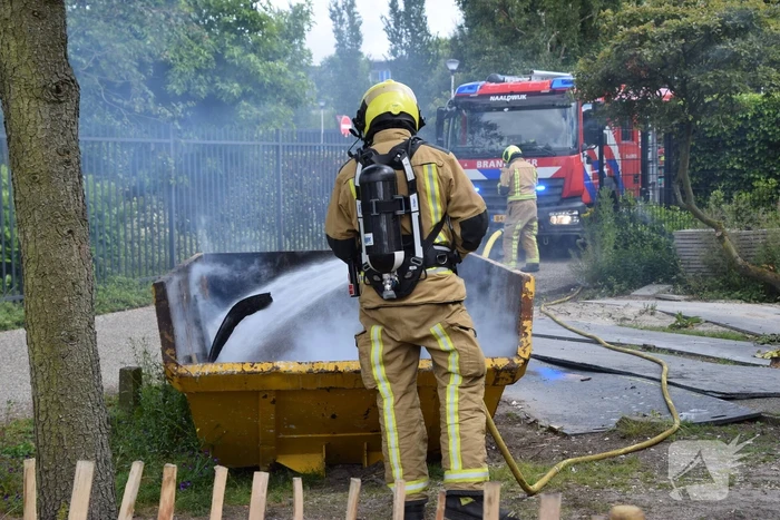 Brandweer blust brand in bouwcontainer