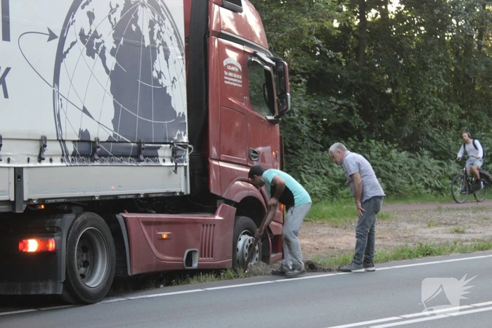 Vrachtwagen rijdt zich vast in berm