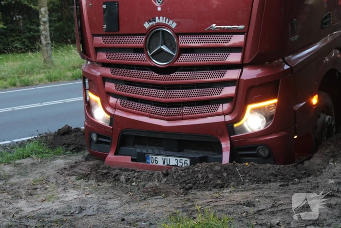 Vrachtwagen rijdt zich vast in berm