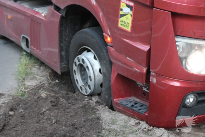 Vrachtwagen rijdt zich vast in berm