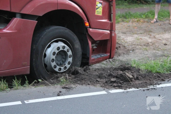 Vrachtwagen rijdt zich vast in berm