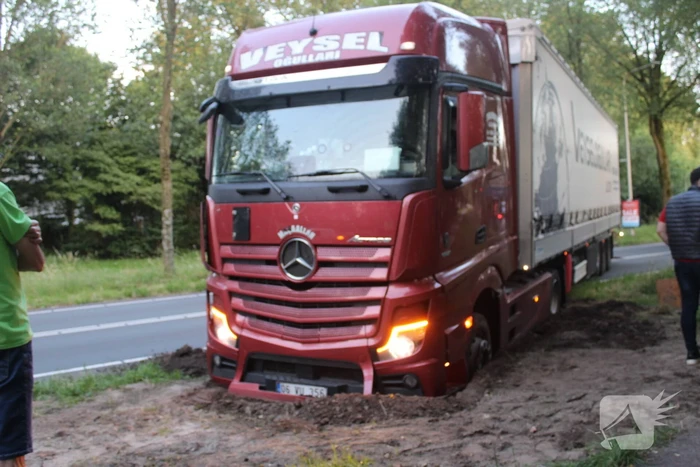Vrachtwagen rijdt zich vast in berm