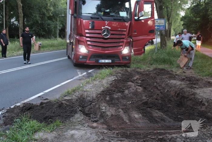 Vrachtwagen rijdt zich vast in berm