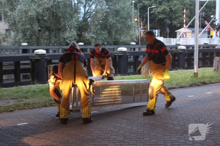 Persoon onwel op peiler van brug, brandweer haalt hem eraf