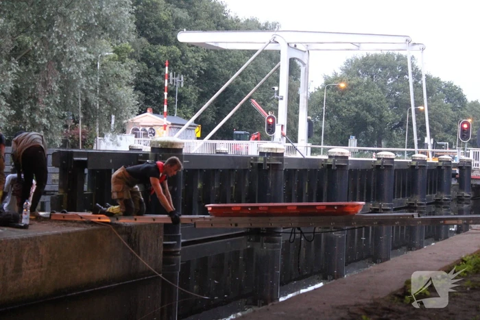 Persoon onwel op peiler van brug, brandweer haalt hem eraf