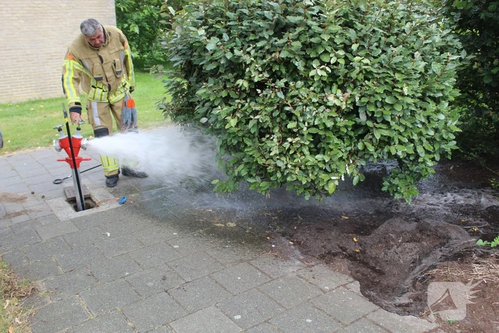 Brandweer blust buitenbrand met water uit brandkraan