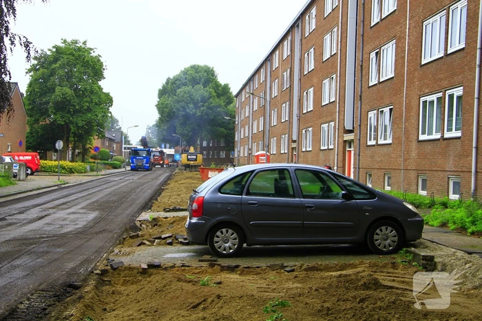 Asfalt om geparkeerde auto verwijderd