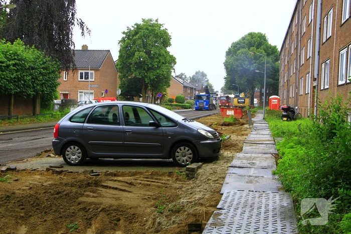 Asfalt om geparkeerde auto verwijderd