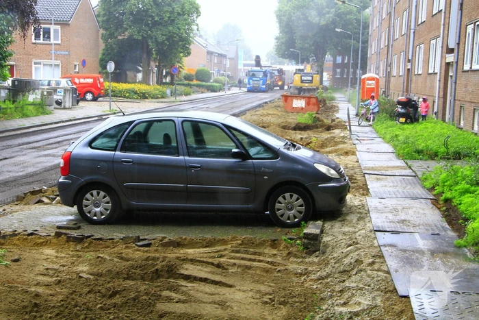 Asfalt om geparkeerde auto verwijderd