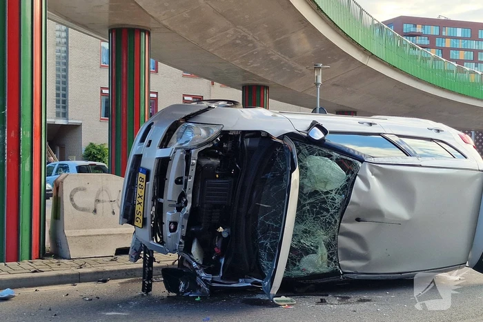 Auto belandt op zijkant, vrouw gewond