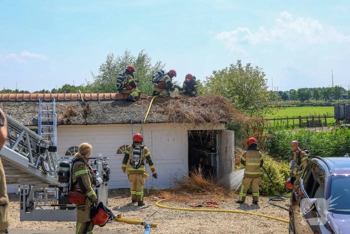 Brandweer blust brand in rietenkap van woning