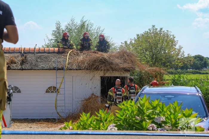 Brandweer blust brand in rietenkap van woning
