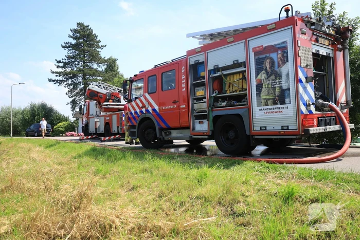 Brandweer blust brand in rietenkap van woning
