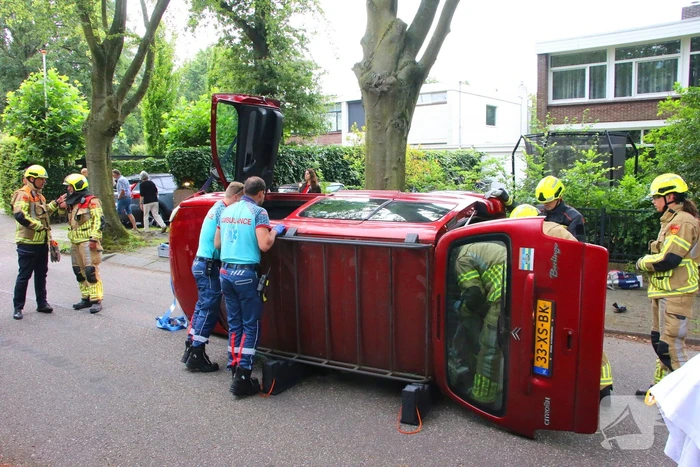 Auto belandt op zijkant na botsing tegen boom