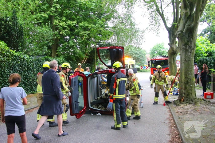 Auto belandt op zijkant na botsing tegen boom