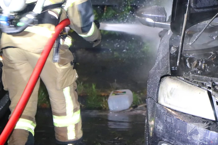 Brandweer blust brandende auto