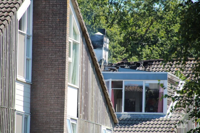Brandweer blust brand in dak van woning