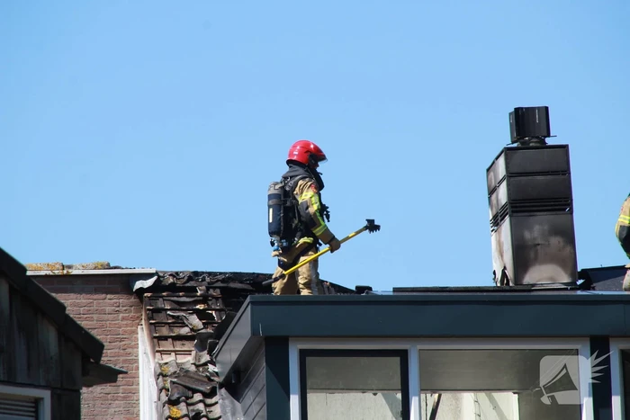 Brandweer blust brand in dak van woning