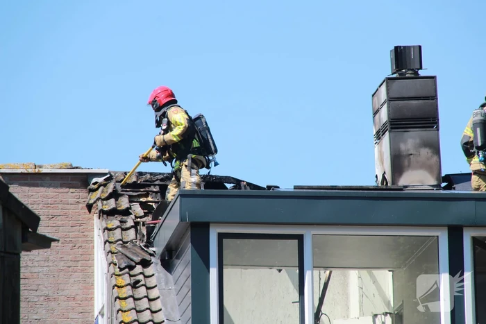 Brandweer blust brand in dak van woning