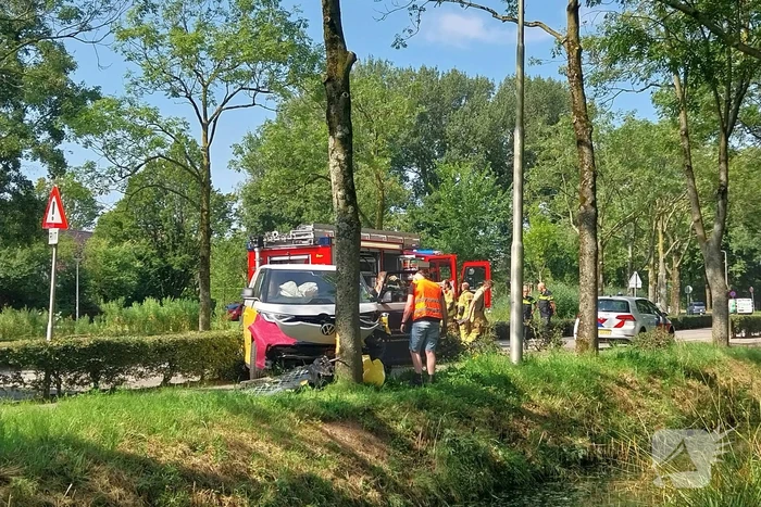 Elektrische bedrijfsbus raakt van de weg en belandt tegen boom